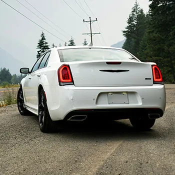 White sedan parked on forest road
