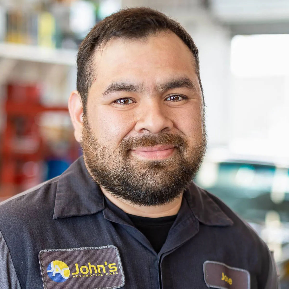 Smiling mechanic in work uniform at garage